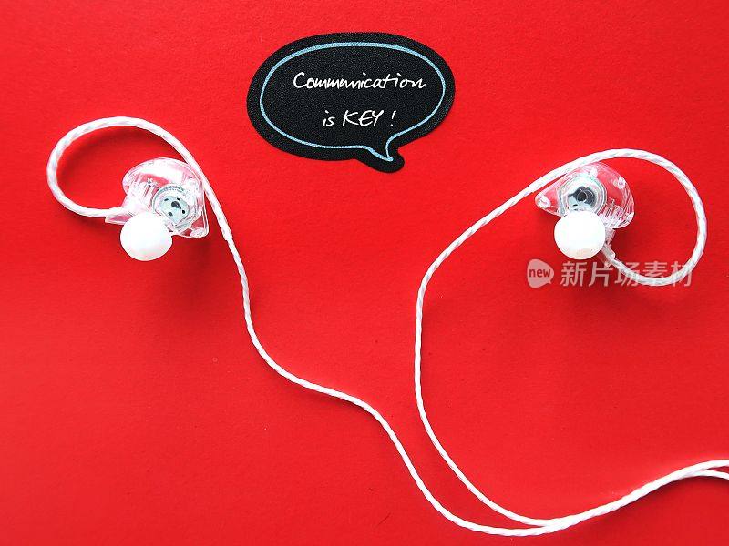 耳机在红色背景上粘贴便条，手写文字COMMUNICATION IS KEY，意思是沟通是良好关系和领导的关键，解释什么是经历和真正需要的